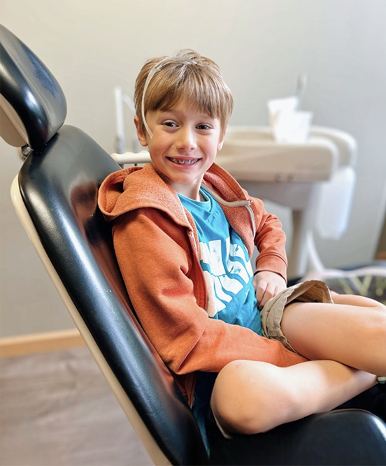 Young Miller Orthodontics Patient Smiling While Sitting In Orthodontist Chair