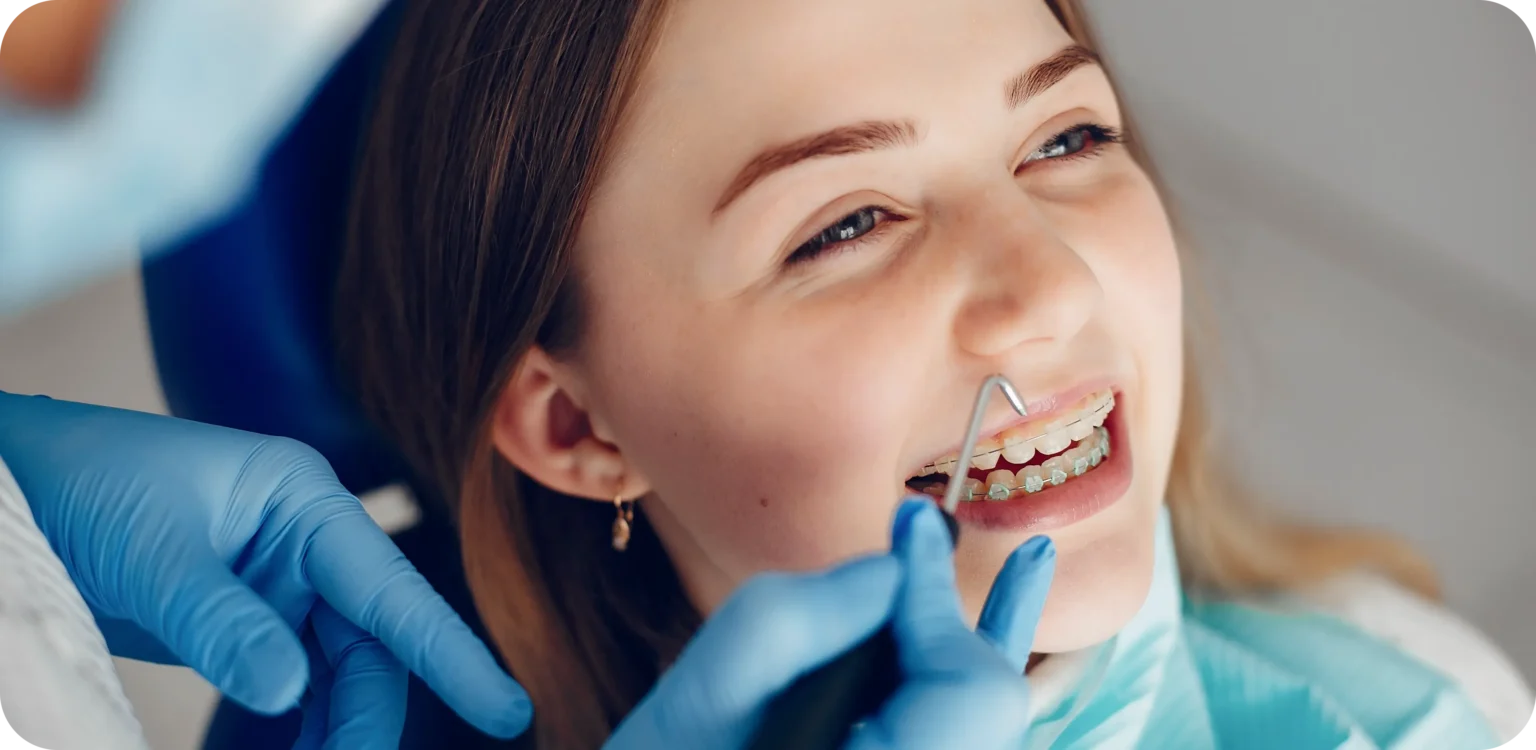 Smiling girl with braces during orthodontic appointment